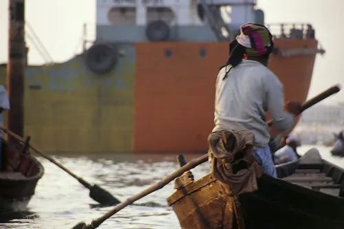 Boat in front of freighter on Dhaka River