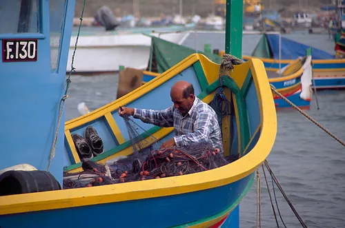 Fisherman mending his nets